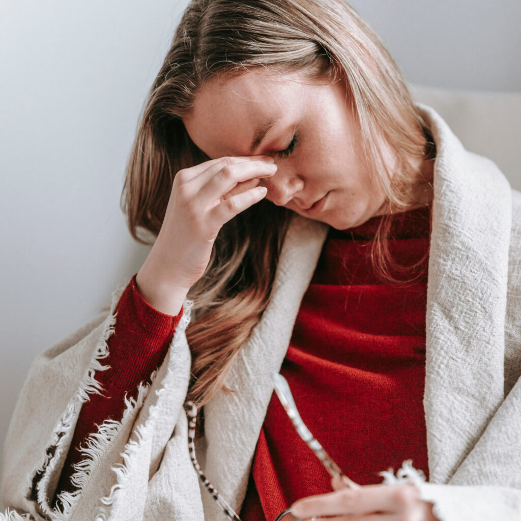 Woman Touches her Head in Pain